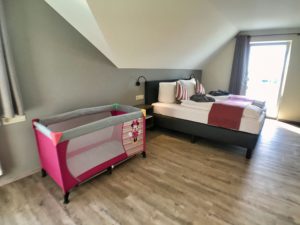 large bedroom with baby bed and ensuite